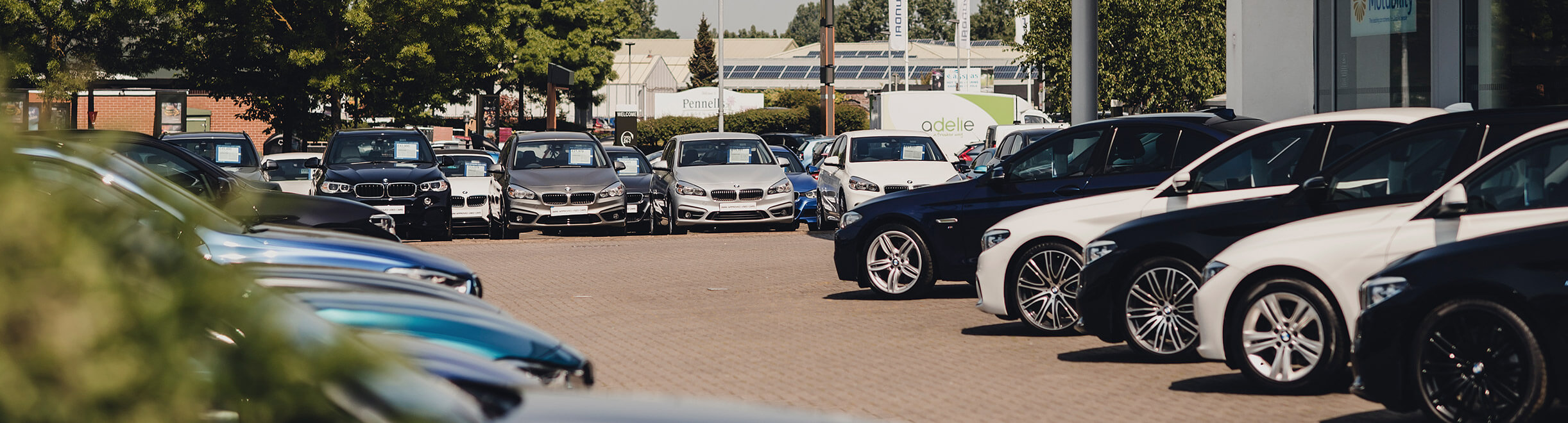 Enhanced vehicle specification data maximise margins, saves valuable time and builds trust. A dealership forecourt with a large number of vehicles