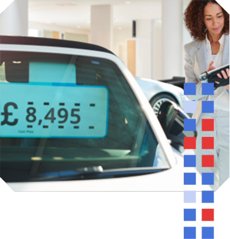 Autotrader Valuations A sales manager standing next to a car with an impartial vehicle price tag